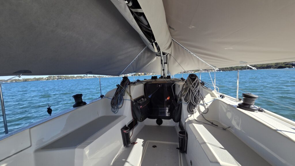 Overall protection cover — cockpit view looking forward, Italia Yachts 9.98, Lake Macquarie View from the cockpit looking forward under a custom WeatherMax overall protection cover fitted to an Italia Yachts 9.98, showing full deck coverage, Lake Macquarie